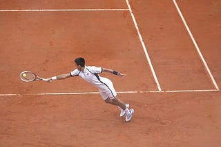 Tennis Player That Looks Like Novak Djokovic Playing Tennis On A Tennis Court.