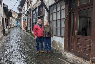 Man and woman posing on a cobblestone street