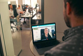 agile team member in office meeting with colleague via video call