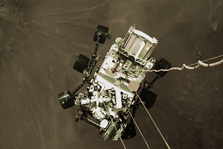 A photo taken by Perseverance’s landing jetpack as it lowers the rover onto the Martian surface.