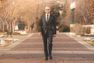 Salvador Aceves walks outdoors on the Regis University Northwest Denver campus.