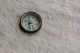 An old-fashioned compass lying on a piece of linen