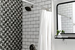 black & white tiled shower, white shower curtain open