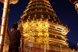 Author looking at a golden temple in Thailand