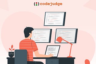 An application developer coding on a laptop with a multi-screen setup.