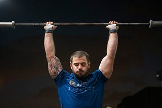 mat fraser warming up with a barbell over his head