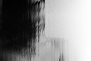 A woman’s image distorted behind a screen