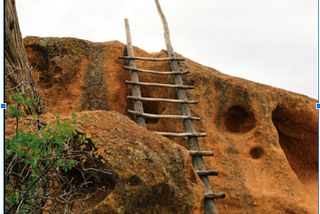 A ladder against a rugged hill.