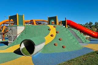 A children’s playground with slide, tunnel and climbing wall