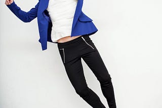 Color photo of a woman excitedly jumping for joy and kicking her feet together over a good life.