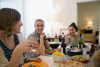 Friends laughing and enjoying dinner party