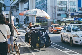 Street vendor in Manila with cars and pedestrians.