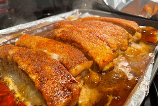 Freshly finished dry rubbed pork ribs still in the pan and steaming