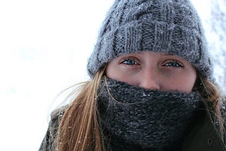 Young woman bundled up in snow, closeup