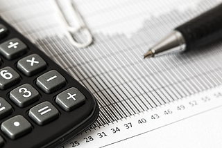 calculator and pen sitting on top of paper