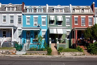 Red, silver, blue, and green row houses in an American city