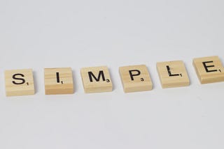 A picture of Scrabble tiles that spell out the word “SIMPLE”.