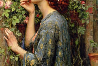 A romantic painting titled “The Soul of the Rose” by John William Waterhouse (1908), depicting a woman with red hair, draped in a patterned robe, gently leaning in to smell a blooming pink rose. The scene is set in a garden, with greenery and stone walls surrounding the lady. The soft lighting and her serene expression add a meditative quality to the painting and an air of stillness.