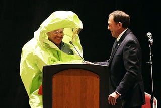 State Senator appears in Hazmat suit to announce that “Everything is Fine”