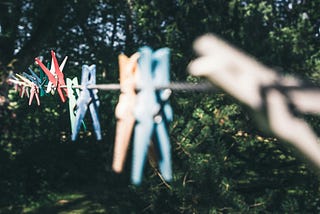 Color clothes pegs on a clothes line in a garden, selective-focus photography.