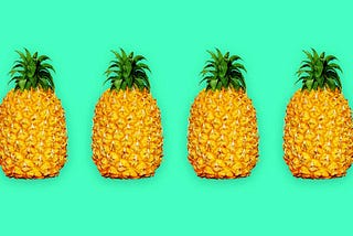 4 pineapples in a line with a teal background
