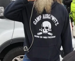 A racist. His shirt says “Work Brings Freedom.” These words hang at Auschwitz, where so many perished during the Holocaust.