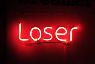 A glowing neon light that says, “loser.”