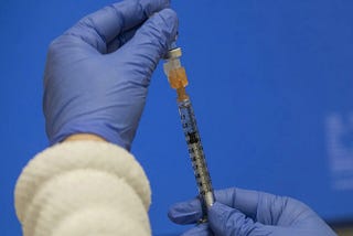 A pharmacist draws up a vaccine at a UW Medicine vaccine clinic in Seattle in 2021. (Ellen M. Banner / The Seattle TImes)