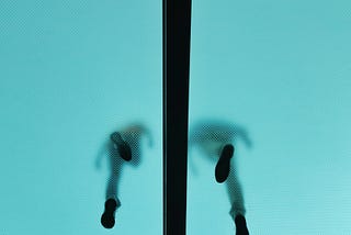 The silhouette of two people’s feet walking side by side, a line between them