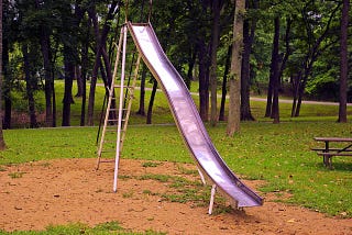 A metal slide standing in the sun.