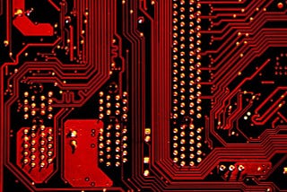 Closeup of circuit board bathed in red light.