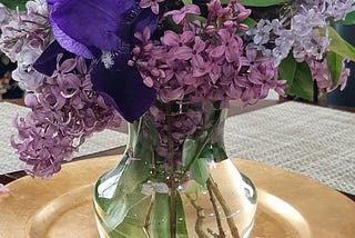 Bouquet with 2 colors of lilacs, purple irises, and an allium.