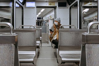 Woman wearing a face mask holding her cell phone