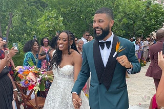 Stef and Maritza, walking down the aisle, surrounded by loved ones on their wedding day.