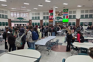 400 students gathered in a cafeteria between classes. Only one is on her phone.