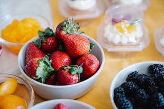 white bowls filled with strawberries and rasperries