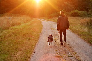 A picture of myself and one of my dogs, a rescue by the way, walking into a sunset.