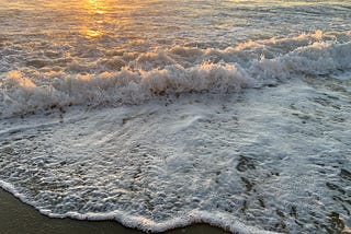 The sun shines on incoming ocean waves.