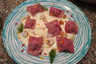 Ravioli di barbabietola con ripieno di patate, menta e gamberoni al burro e salvia, con bisque di…