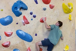 Spencer Morris climbing an indoor bouldering route