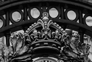 The crown on Buckingham Palace’s gates in black and white.