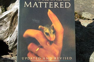 book cover behaving as if the god in all life mattered small furry creature cradled in a womans hand
