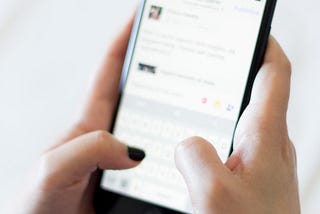 A woman holds her smartphone in two hands