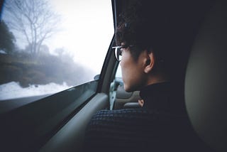 a man sitting in the car looking out the window