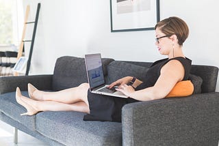 Businesswoman lounging on a couch with her laptop