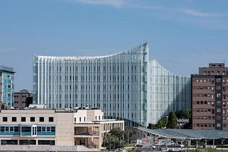 A large glass building in the middle of a city
