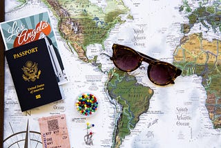 A map of the world with a passport and sunglasses, because you still should travel the world even with a chronic illness or disability