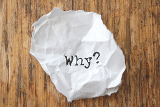 Crumpled paper with ‘why?’ typed on it.