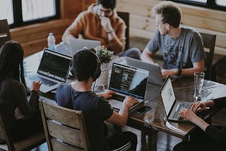 People working at a desk like a startup team.