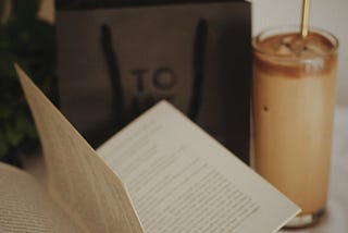 Copo de café gelado com livro com páginas abertas